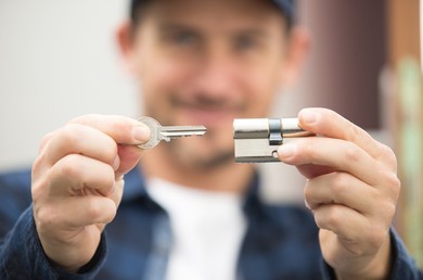 happy locksmith holding a lock and key